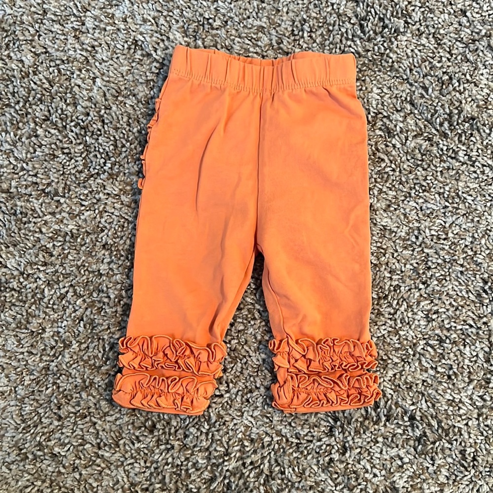 New without tags. Ruffle Butts orange pants size 0-6 months